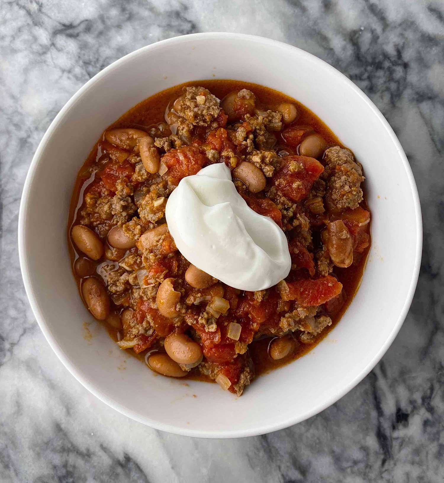 Bowl of chili topped with sour cream